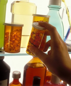 Close-up of a person's hand holding a bottle of pills